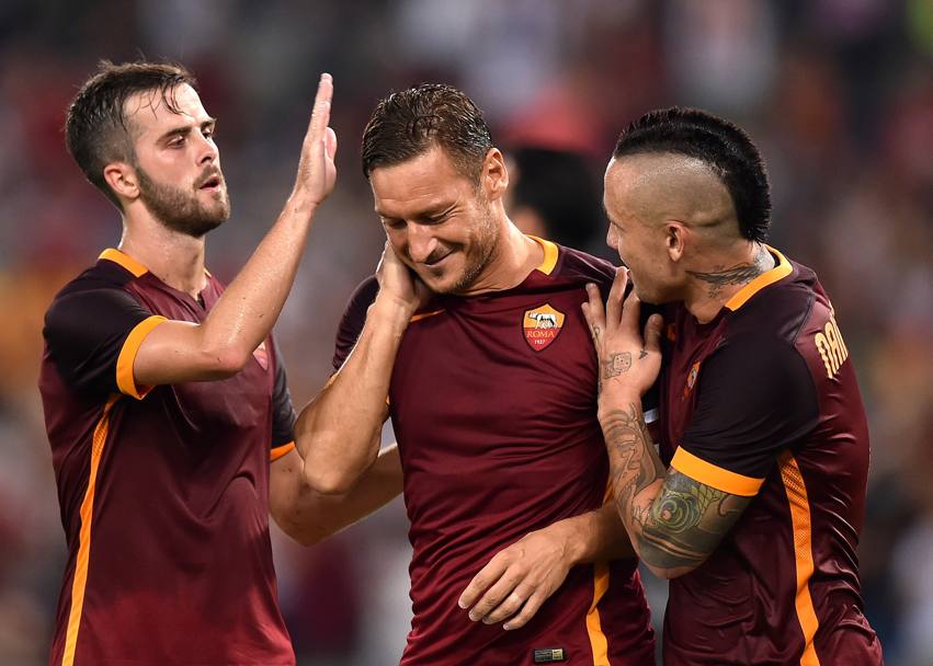 Pjanic e Nainggolan festeggiano Totti dopo il gol del 6-0 su rigore. Afp